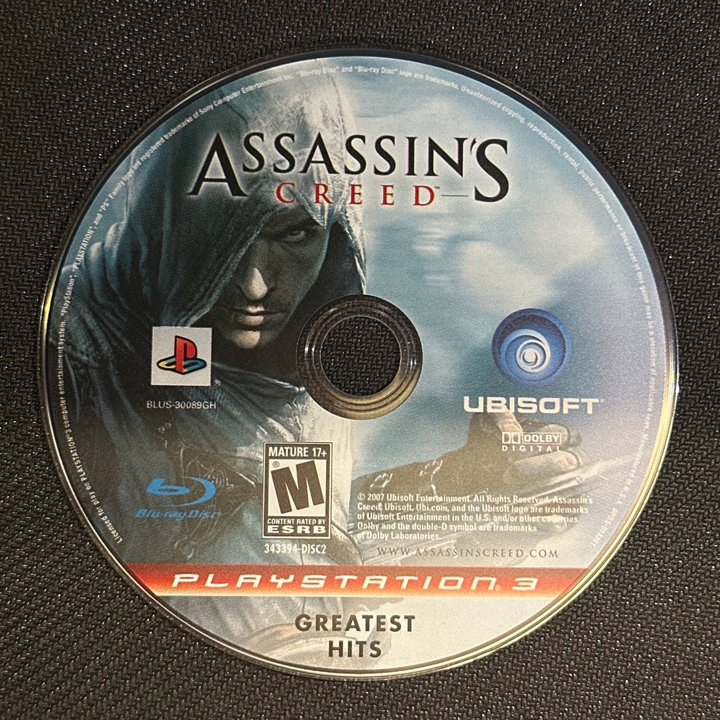 Assassin's Creed game disc on a black surface