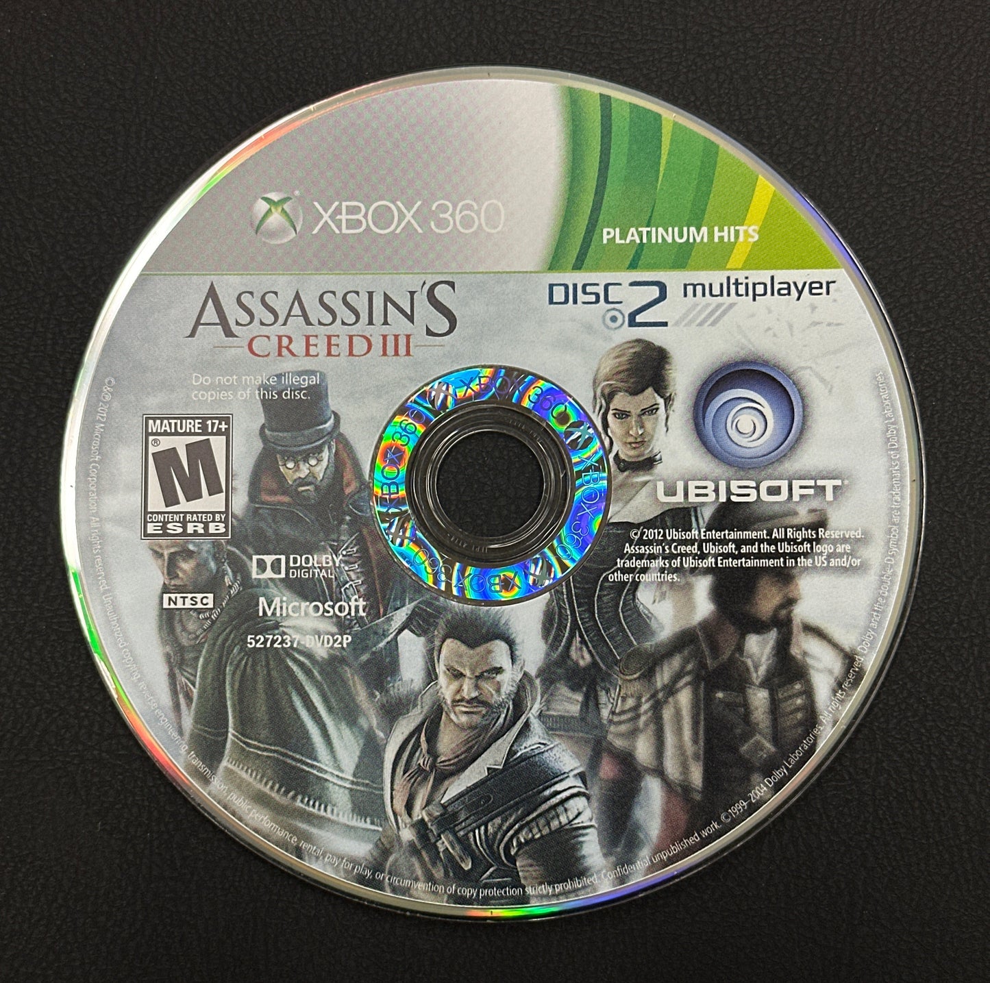 Assassin's Creed III game disc for Xbox 360 on a black background