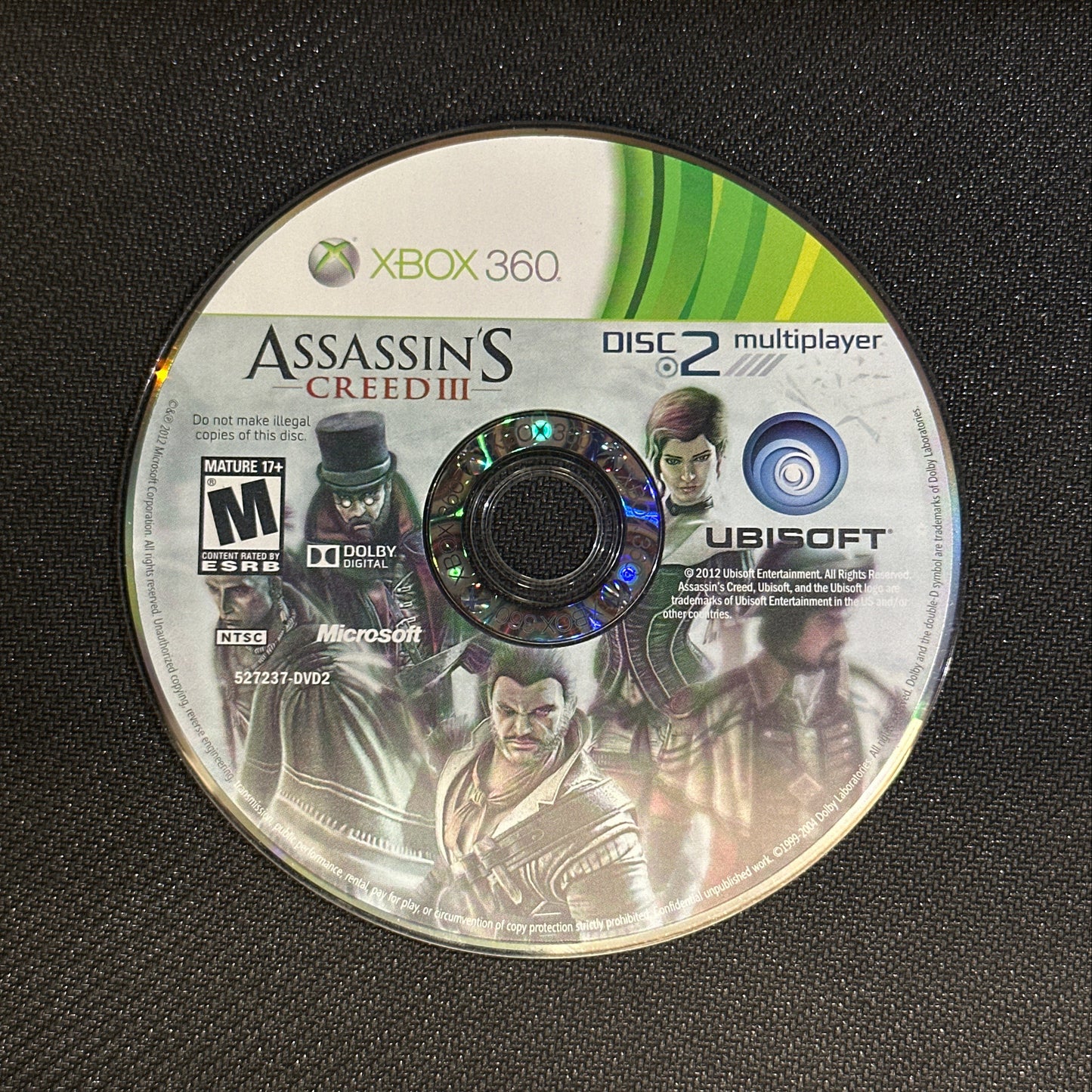 Assassin's Creed 2 game disc for Xbox 360 on a black surface