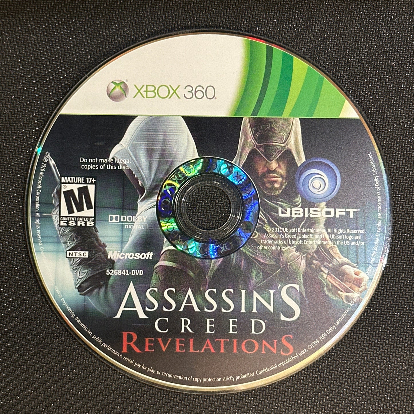 Assassin's Creed Revelations game disc on a black surface