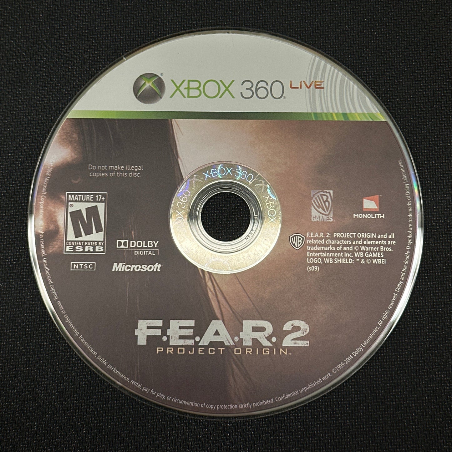 Game disc for 'F.E.A.R. 2' on an Xbox 360 console with a black background