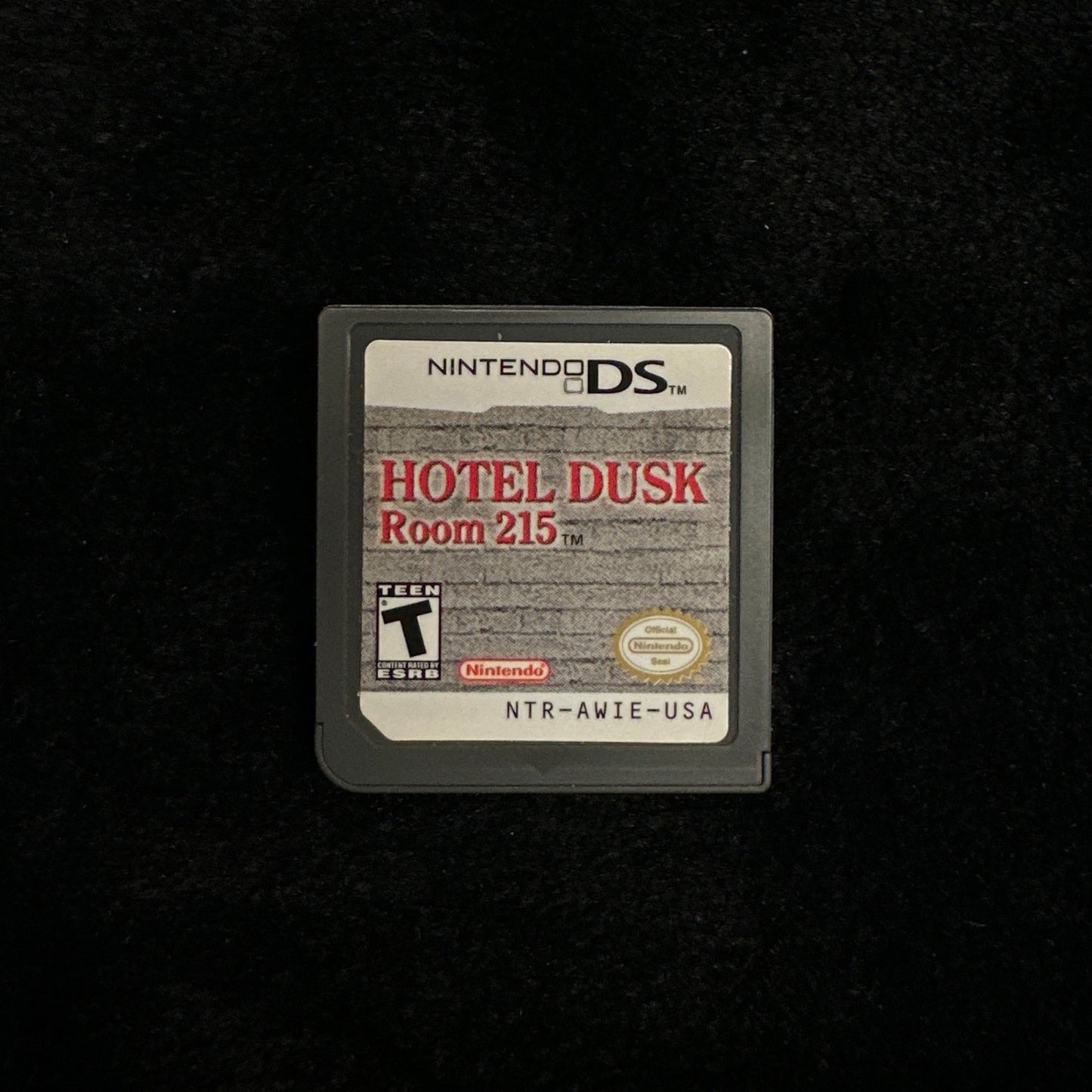 Nintendo DS game cartridge titled 'Hotel Dusk: Room 215' on a black background