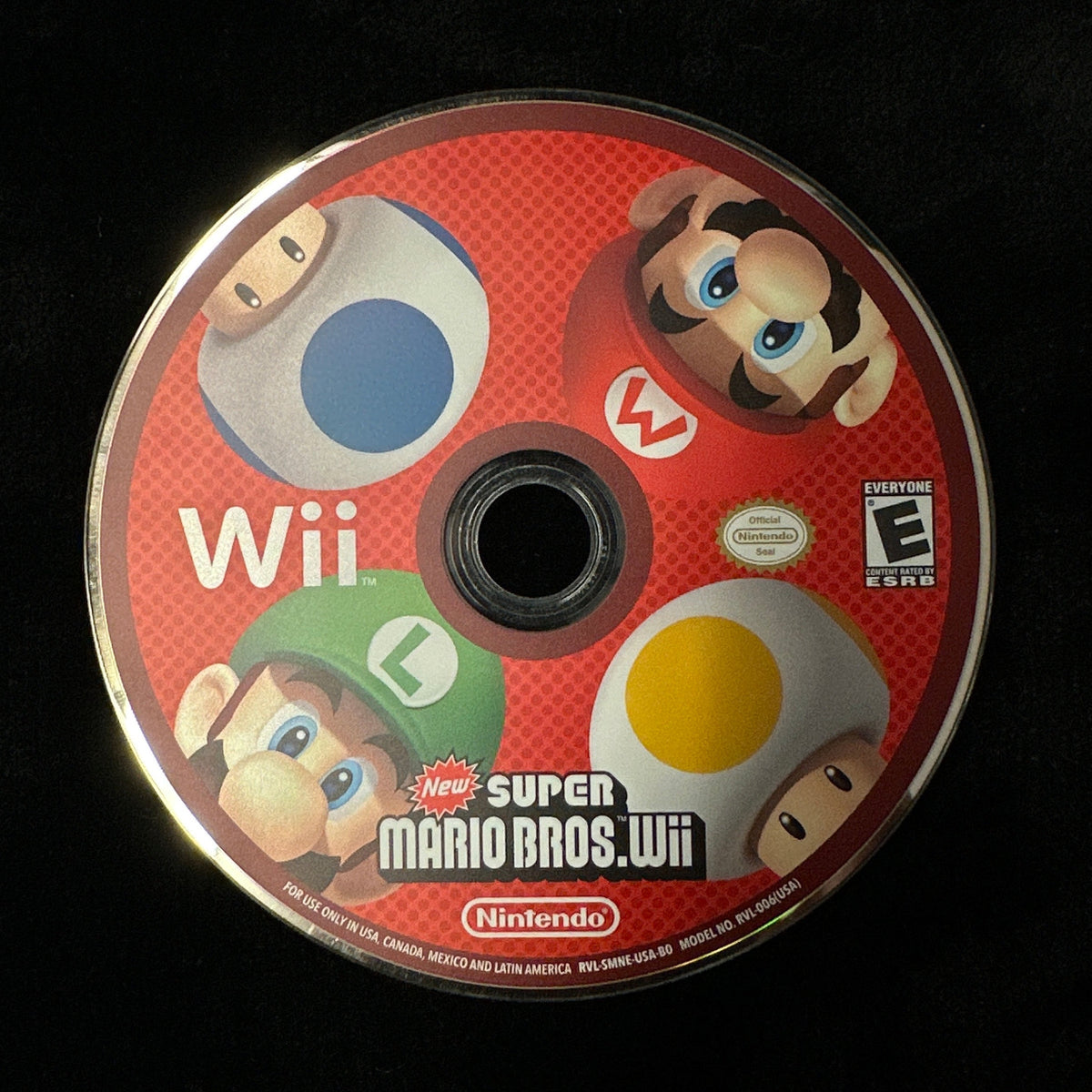 A Nintendo Wii Super Mario Bros. Wii game disc on a black background.
