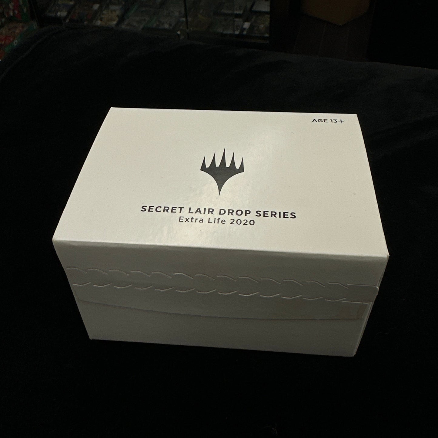White box with a mtg logo on a dark background