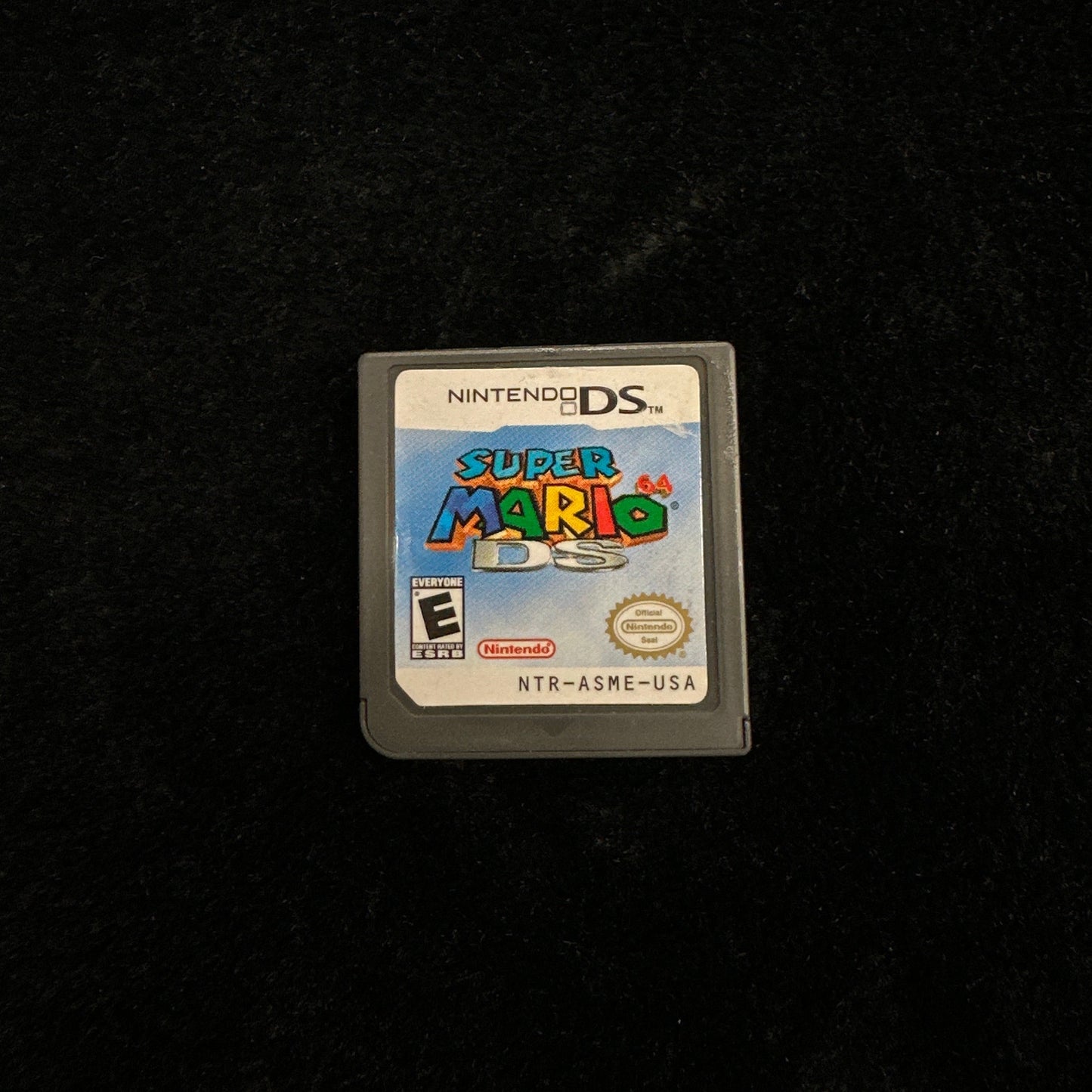 Super Mario game cartridge on a black background