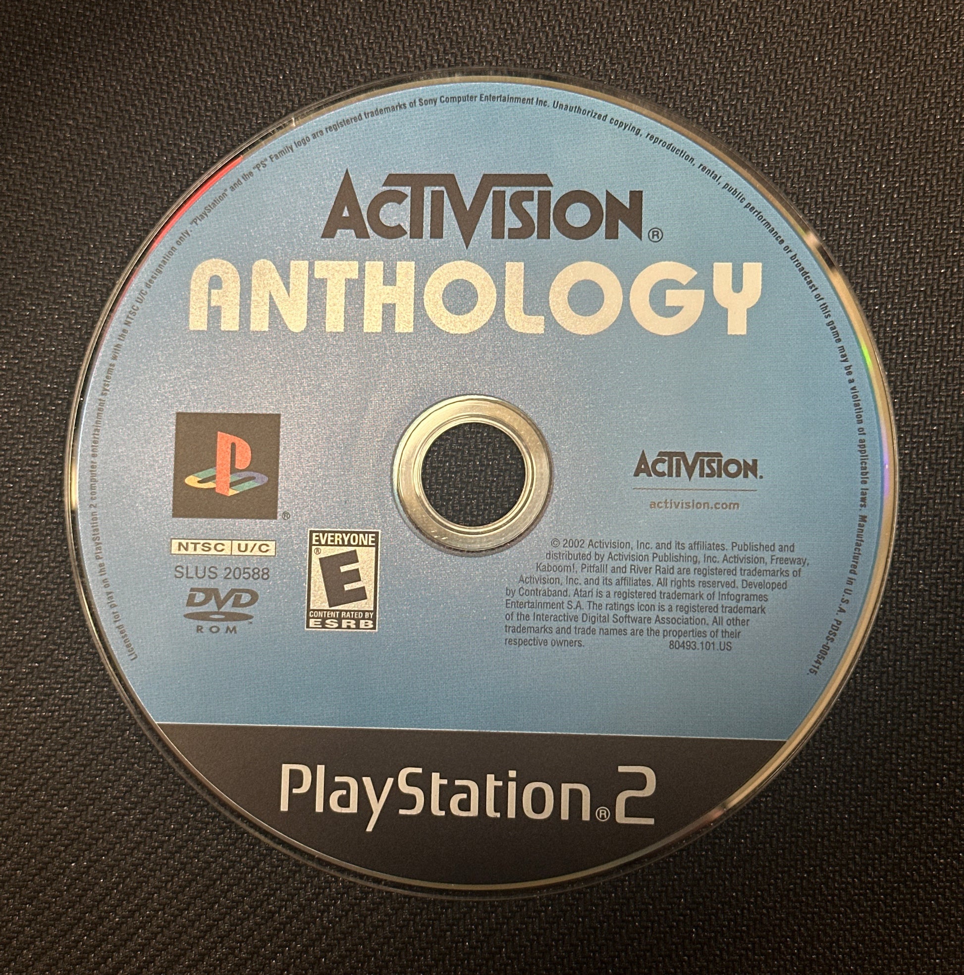PlayStation 2 game disc with Activision logo on a dark textured background