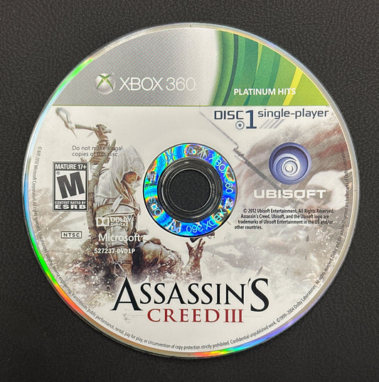 Assassin's Creed III game disc for Xbox 360 on a black background