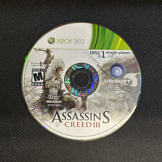 Game disc for 'Assassin's Creed III' on an Xbox 360 console.