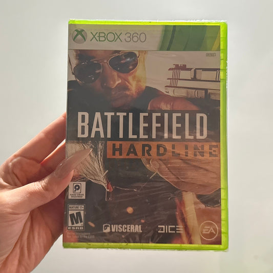 Hand holding a 'Battlefield Hardline' Xbox 360 game case against a neutral background