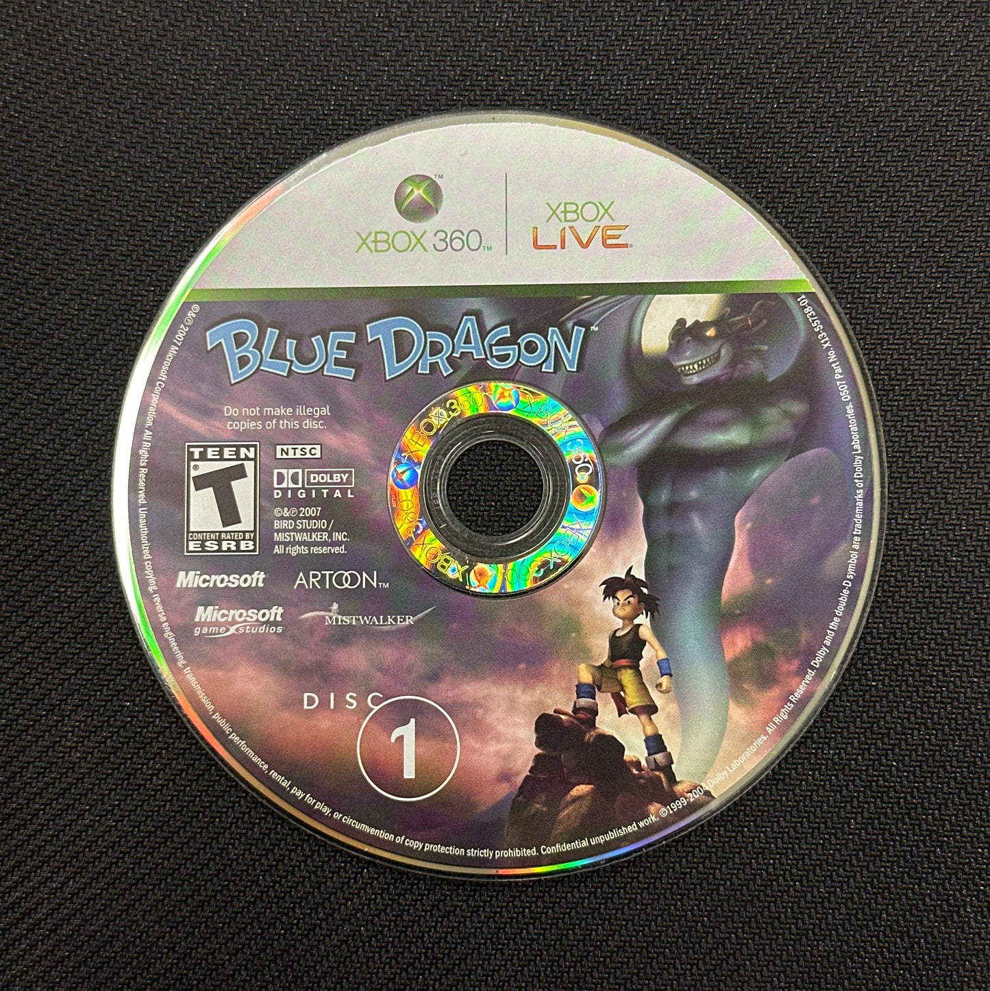 Game disc for 'Blue Dragon' on Xbox 360 with branding and graphics.