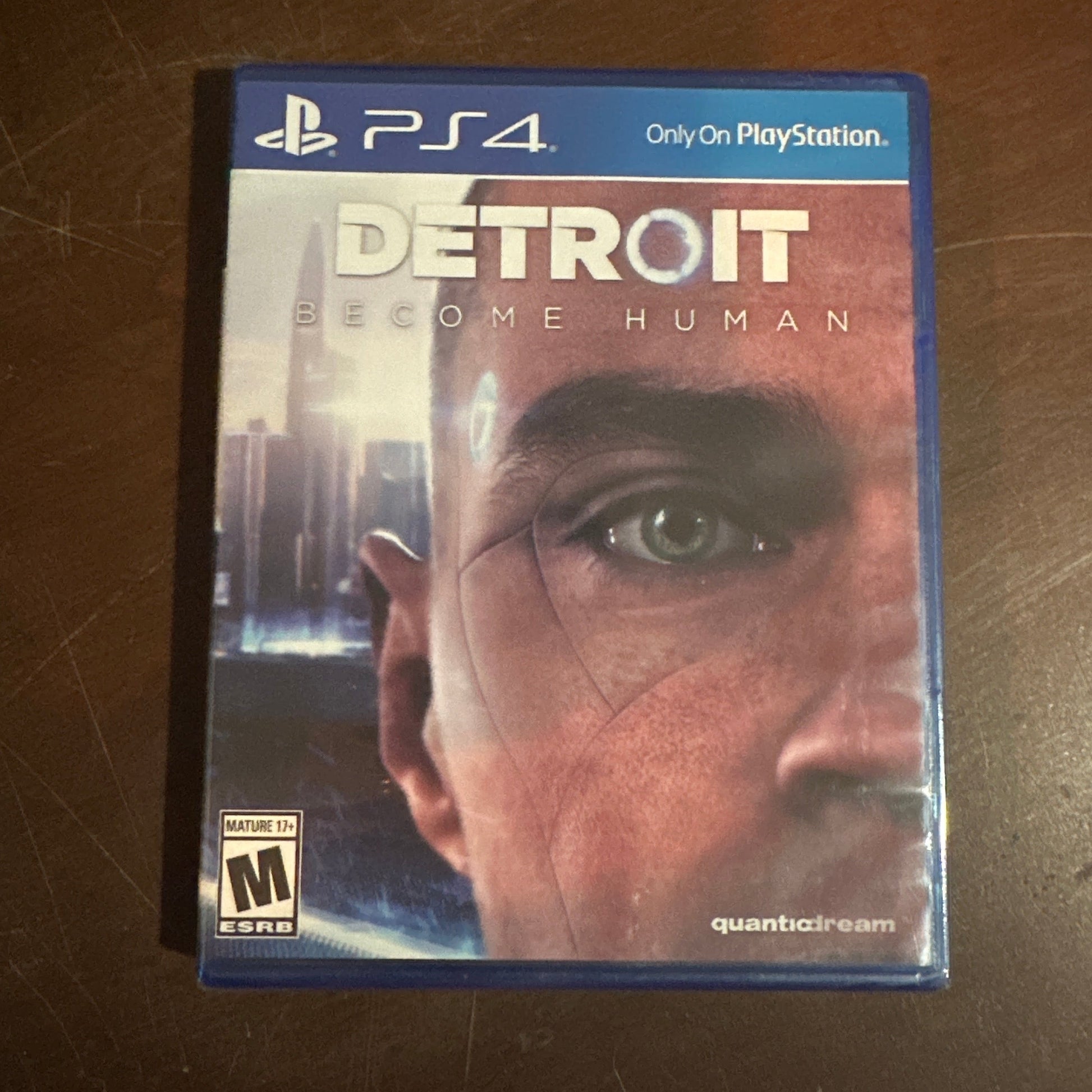 PS4 game case titled 'Detroit: Become Human' on a wooden surface