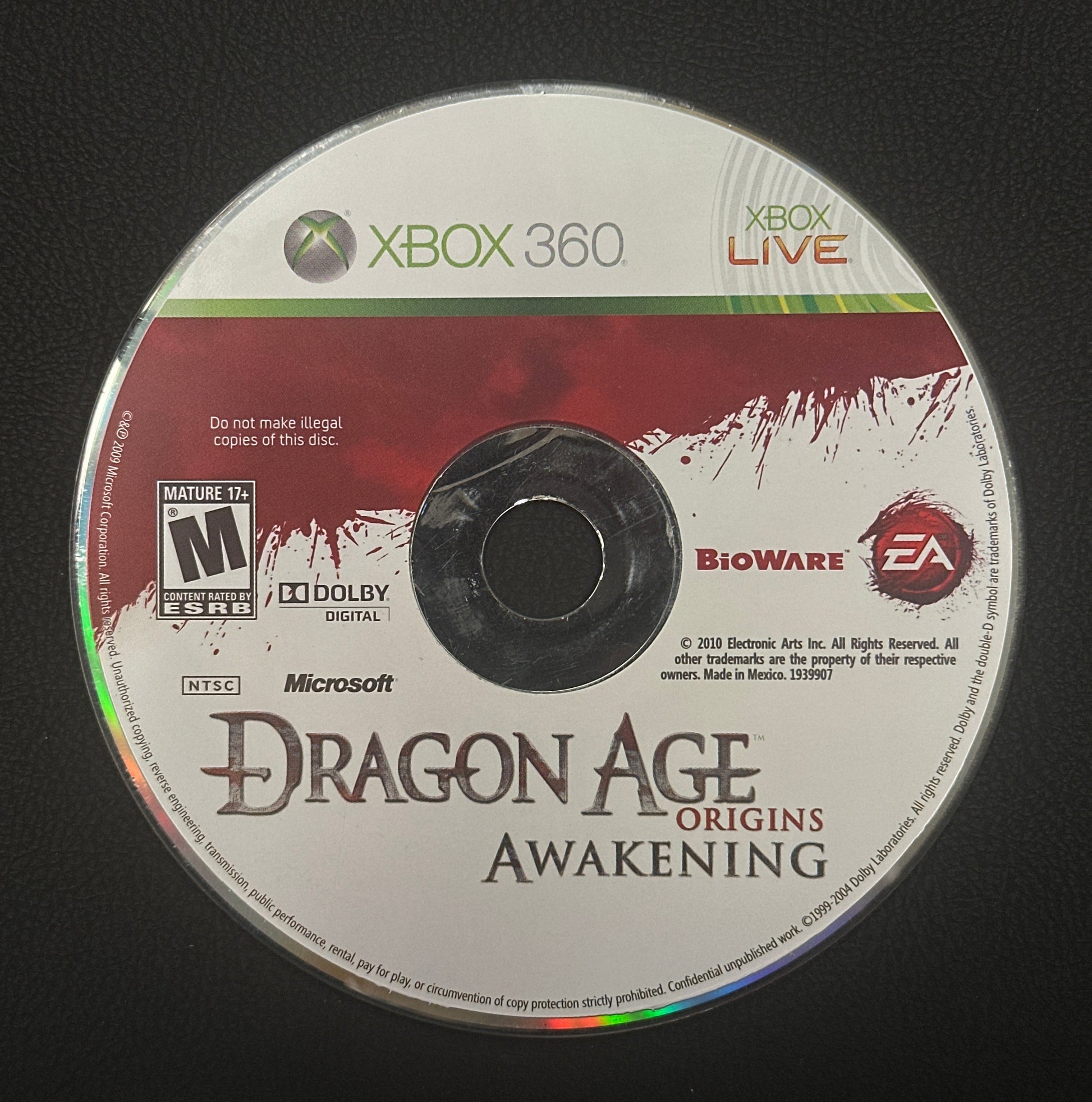 Dragon Age Origins Awakening game disc for Xbox 360 on a black background