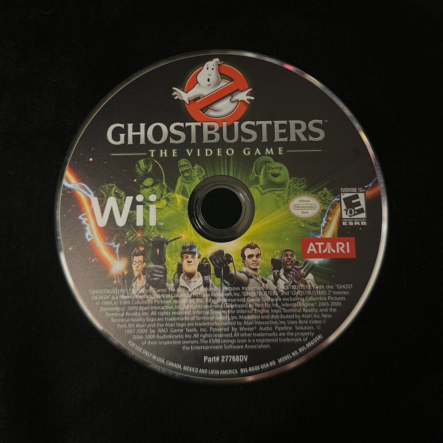 A Ghostbusters: The Video Game for Nintendo Wii console disc, featuring the Ghostbusters logo and characters, resting on a black surface.