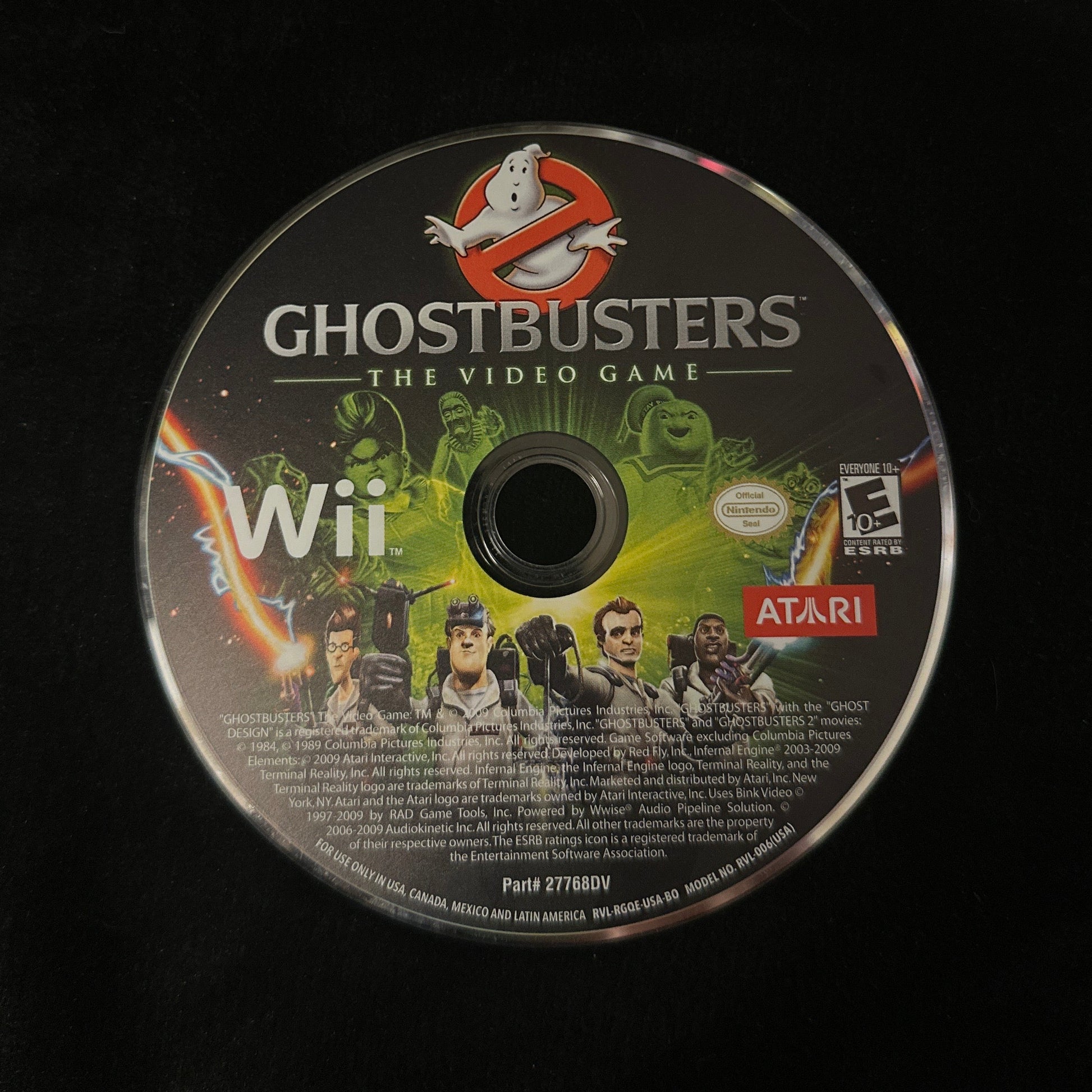 A Ghostbusters: The Video Game for Nintendo Wii console disc, featuring the Ghostbusters logo and characters, resting on a black surface.
