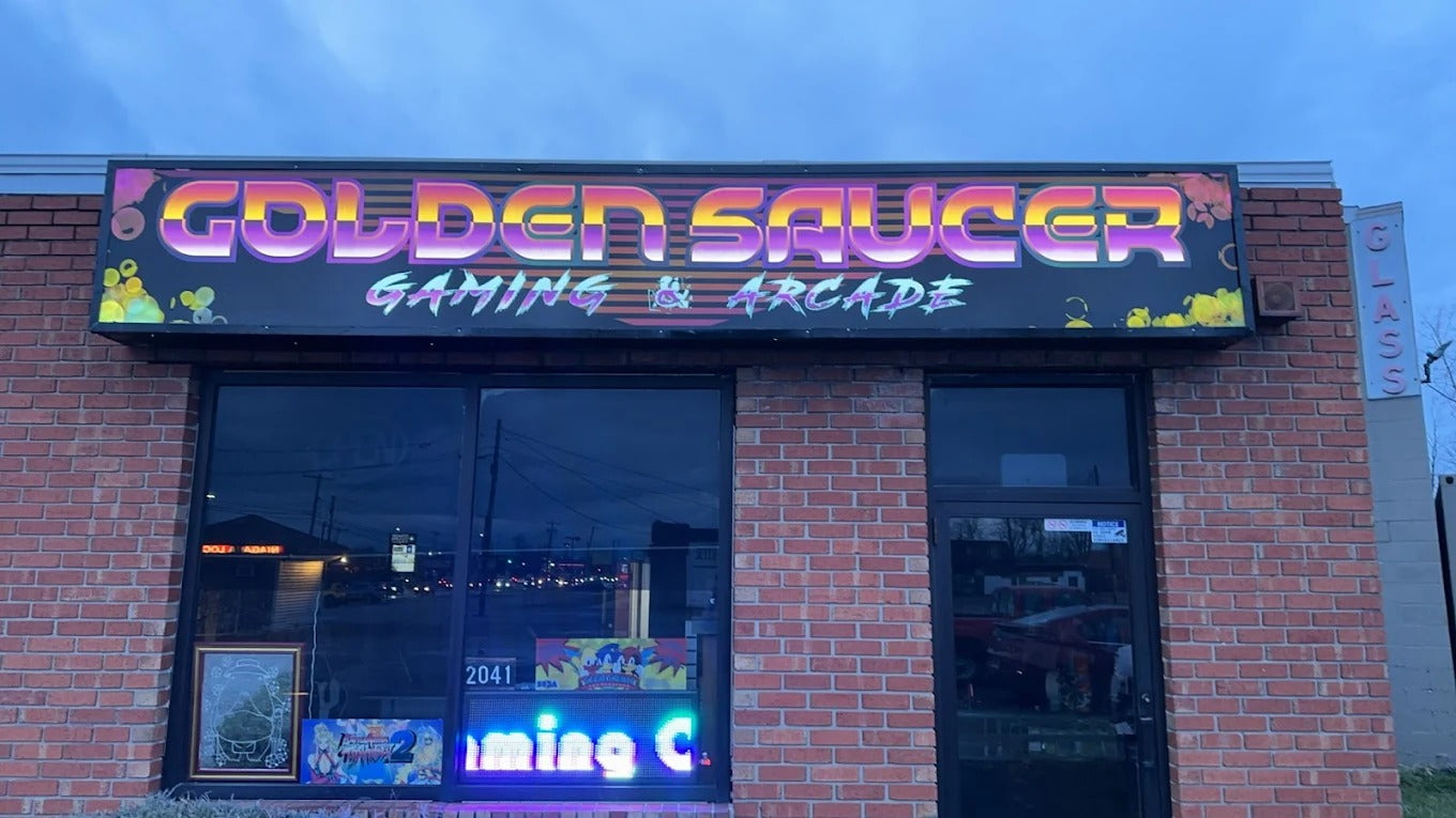Gaming and arcade establishment named 'Golden Saucer' with neon sign and brick facade.