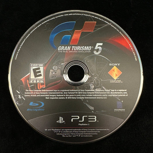 Gaming disc with 'Gran Turismo 5' branding on a black background