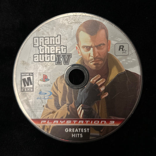 A PlayStation 3 'Grand Theft Auto IV Greatest Hits' game disc resting on a black fabric surface.