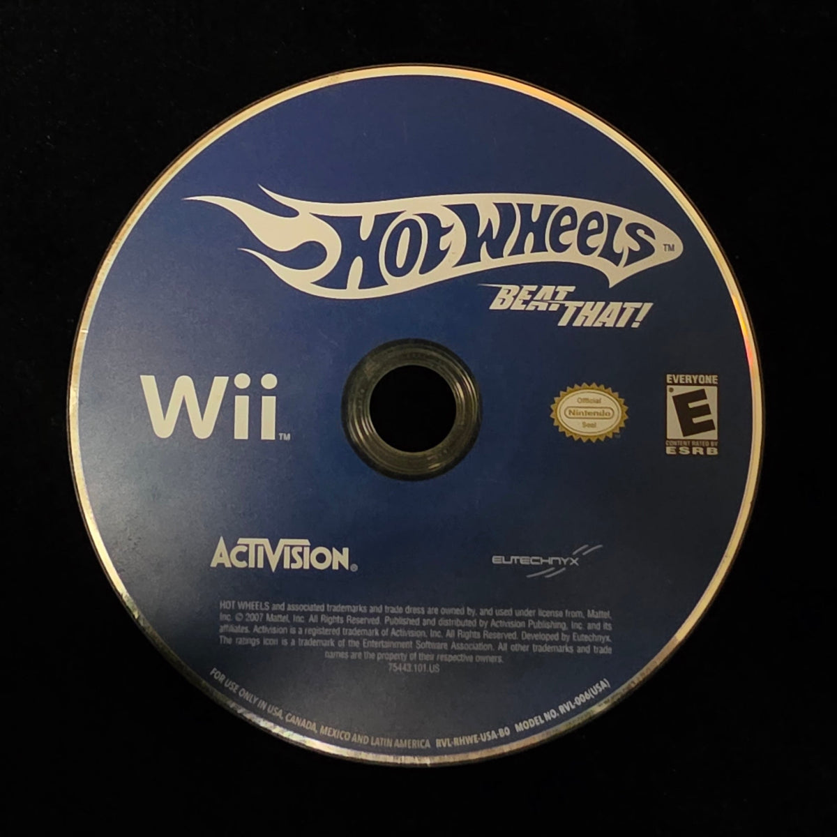 A Hot Wheels Beat That! Wii video game disc for the Nintendo Wii, featuring a blue and white design with the Hot Wheels logo, resting on a black surface.
