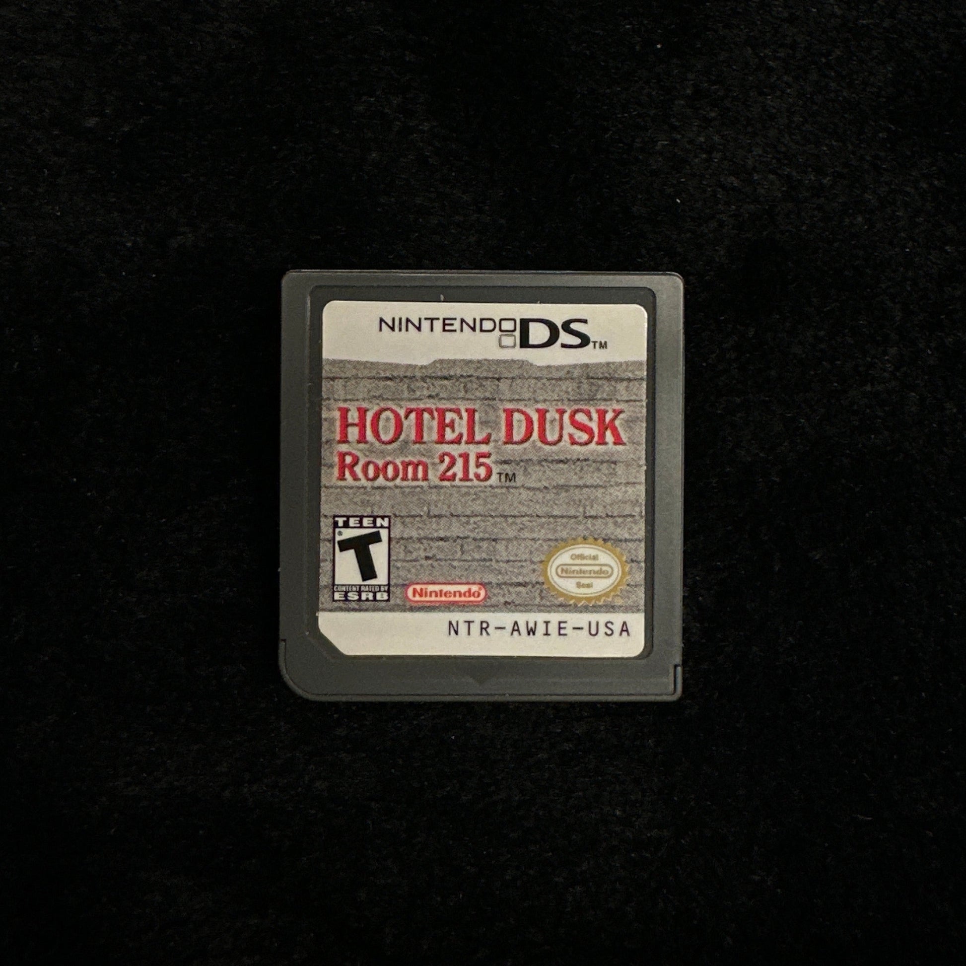 Nintendo DS game cartridge titled 'Hotel Dusk: Room 215' on a black background