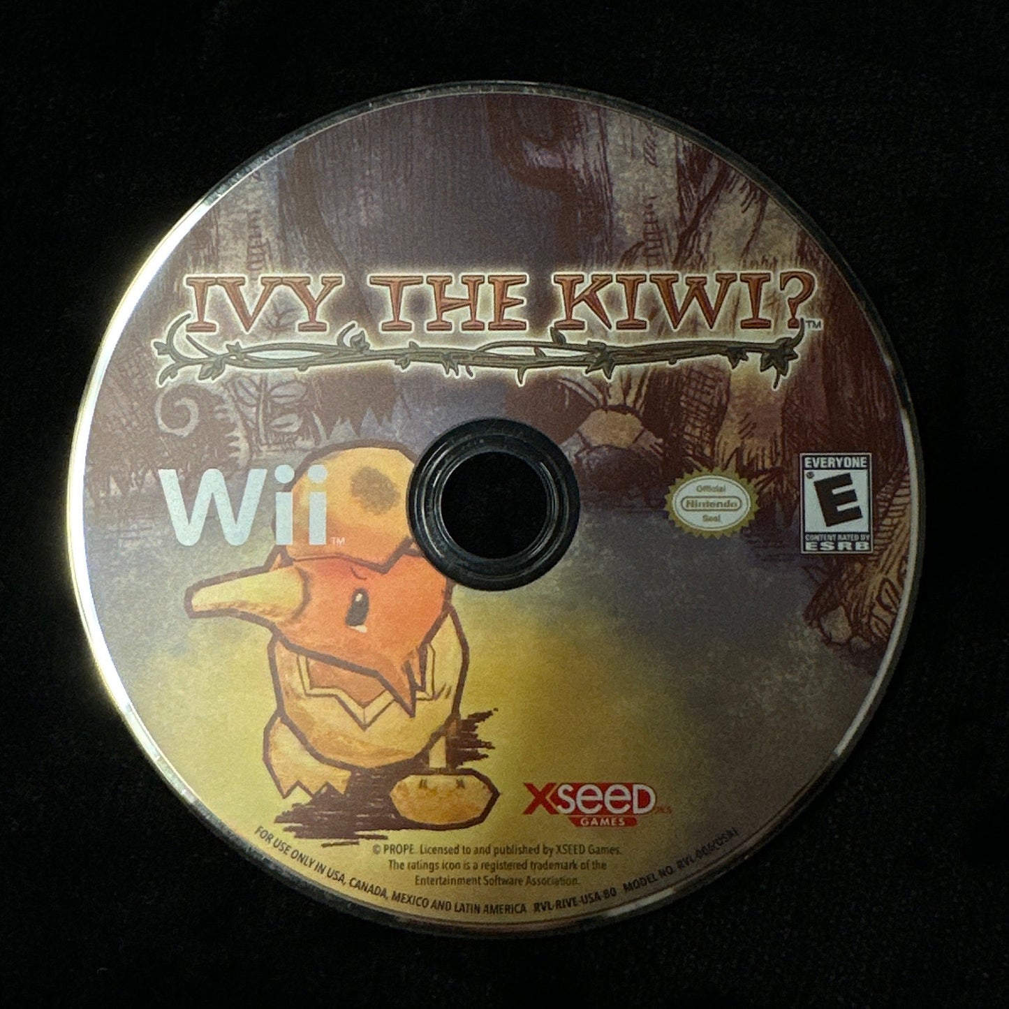 A Wii game disc for 'Ivy the Kiwi?' resting on a black fabric surface. The disc features artwork of the kiwi character and logos for Nintendo Wii and Xseed.