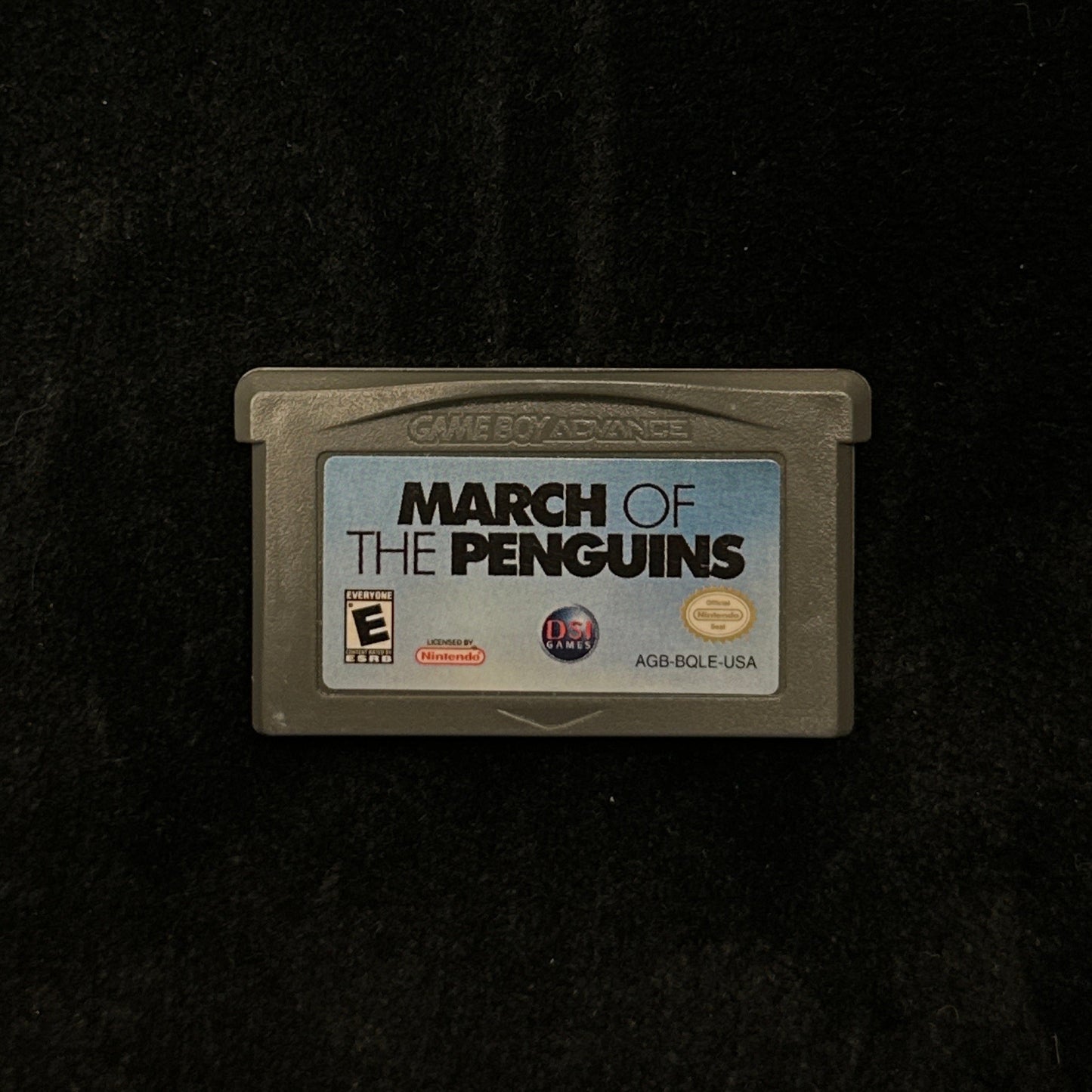 Game cartridge for 'March of the Penguins' on a dark background