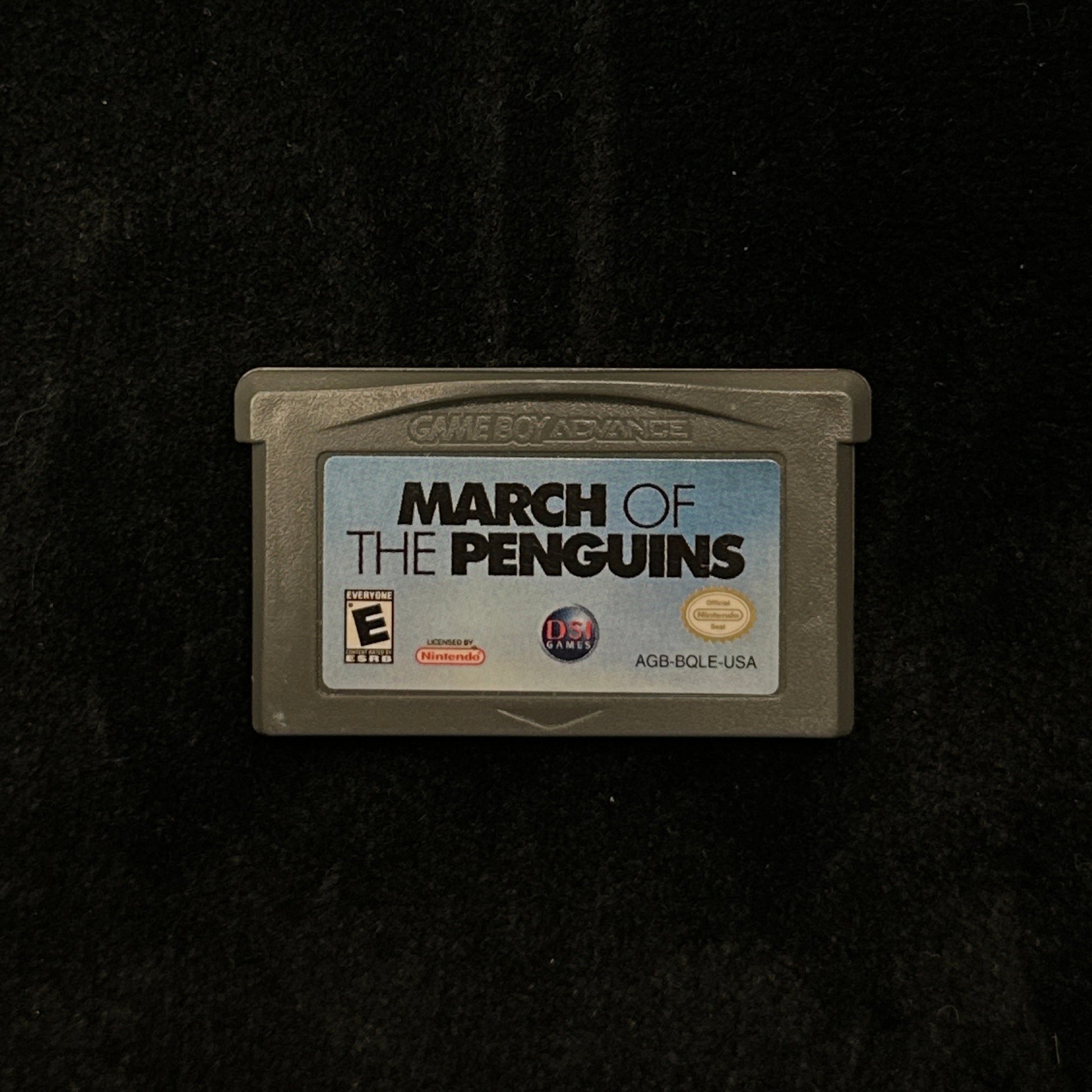 Game cartridge for 'March of the Penguins' on a dark background