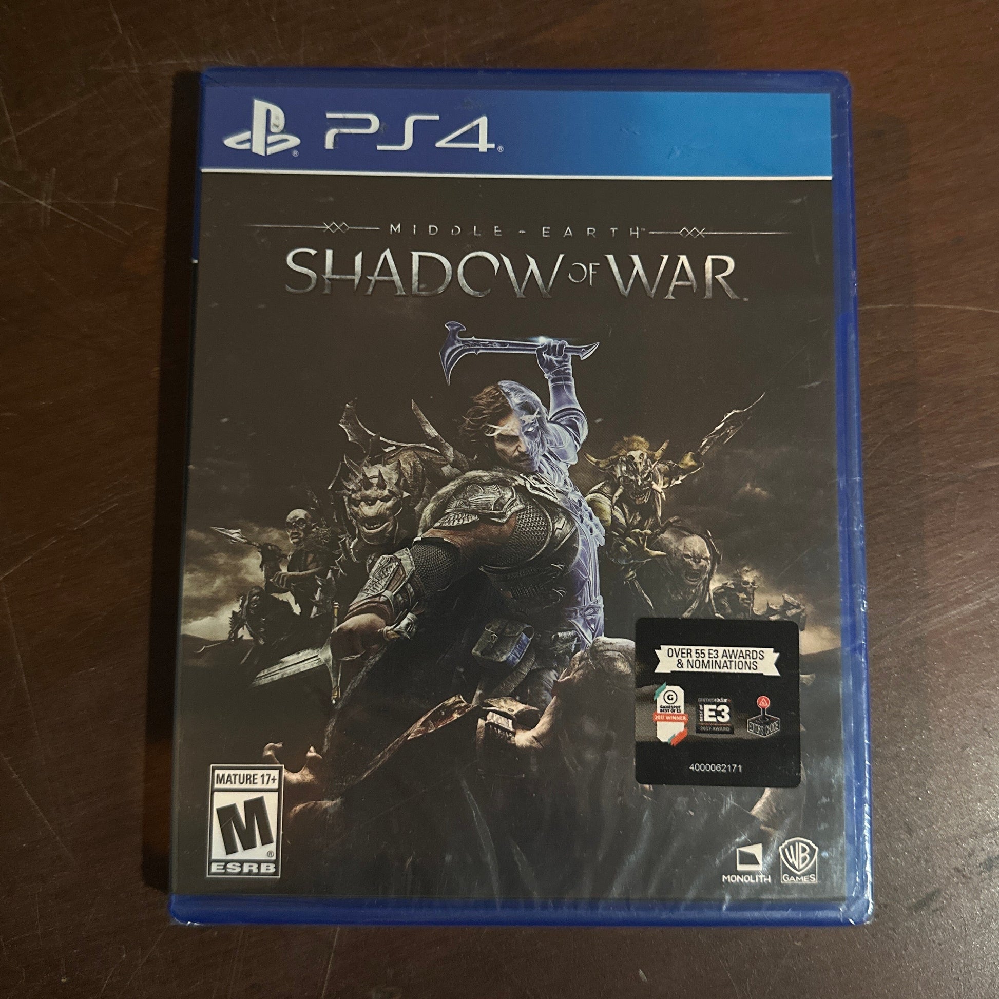 PlayStation 4 game case titled 'Shadow of War' on a wooden surface