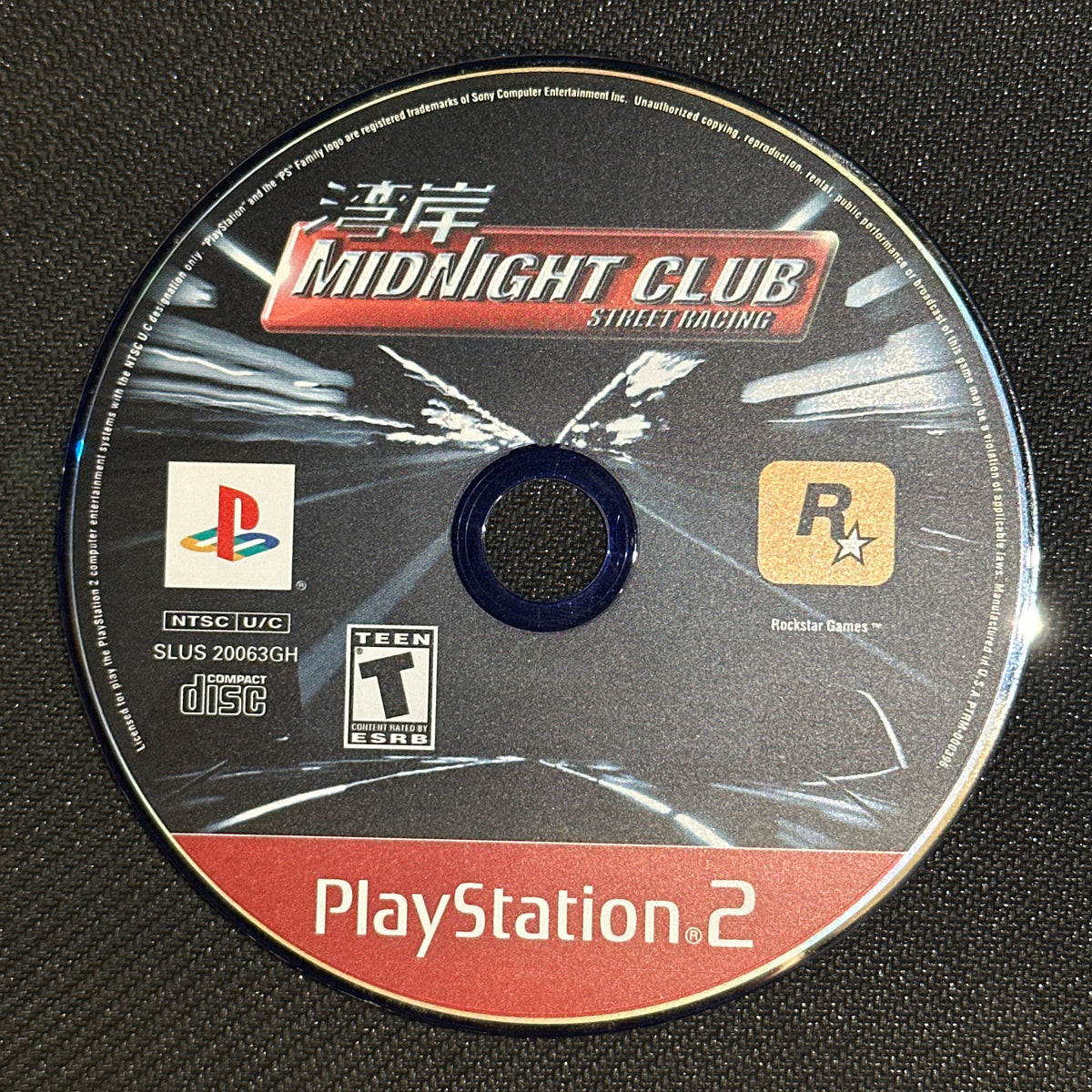PlayStation 2 game disc with 'Midnight Club' on a black textured background