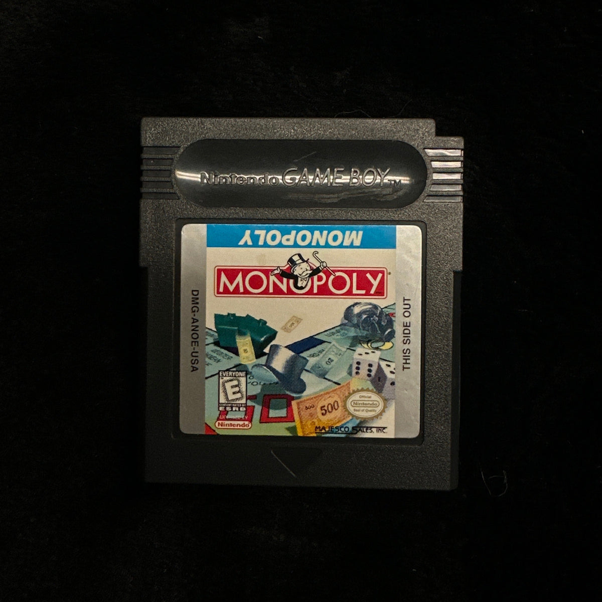 Nintendo Game Boy Monopoly game cartridge on a black background.