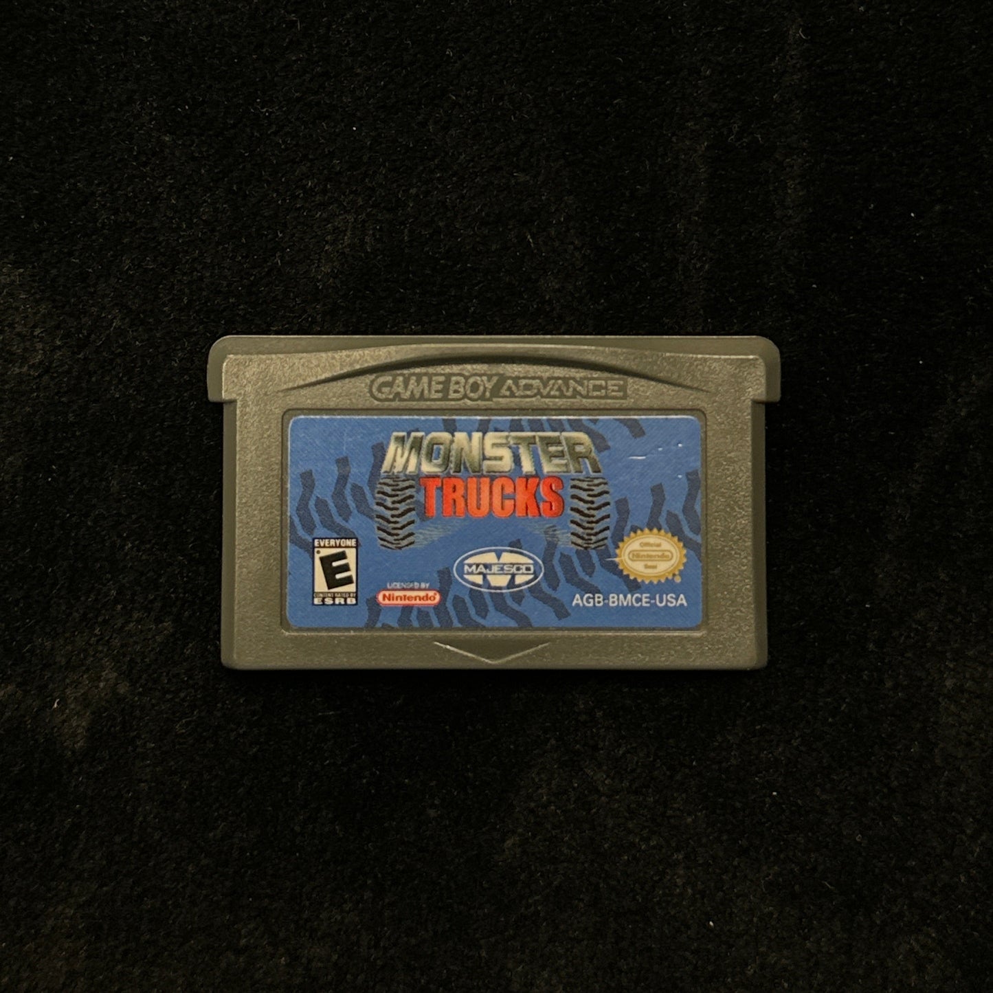 Game cartridge for 'Monster Trucks' on a black background