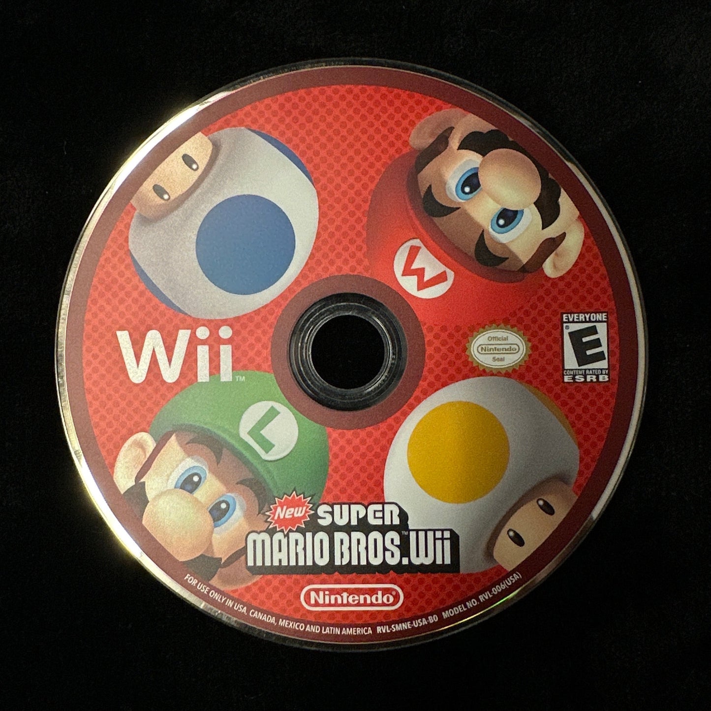 A Nintendo Wii Super Mario Bros. Wii game disc on a black background.