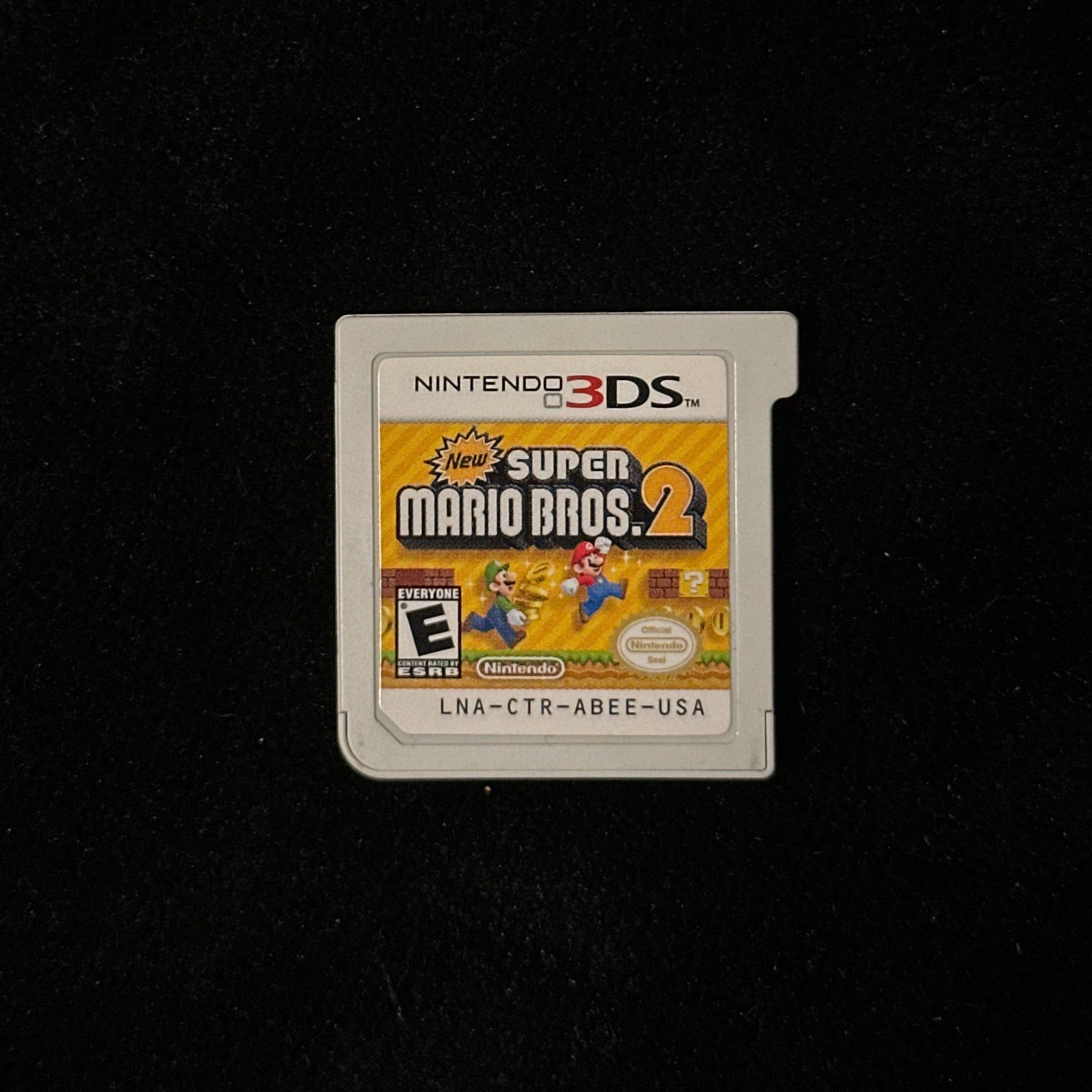 Nintendo 3DS Super Mario Bros. 2 game cartridge on a black background.