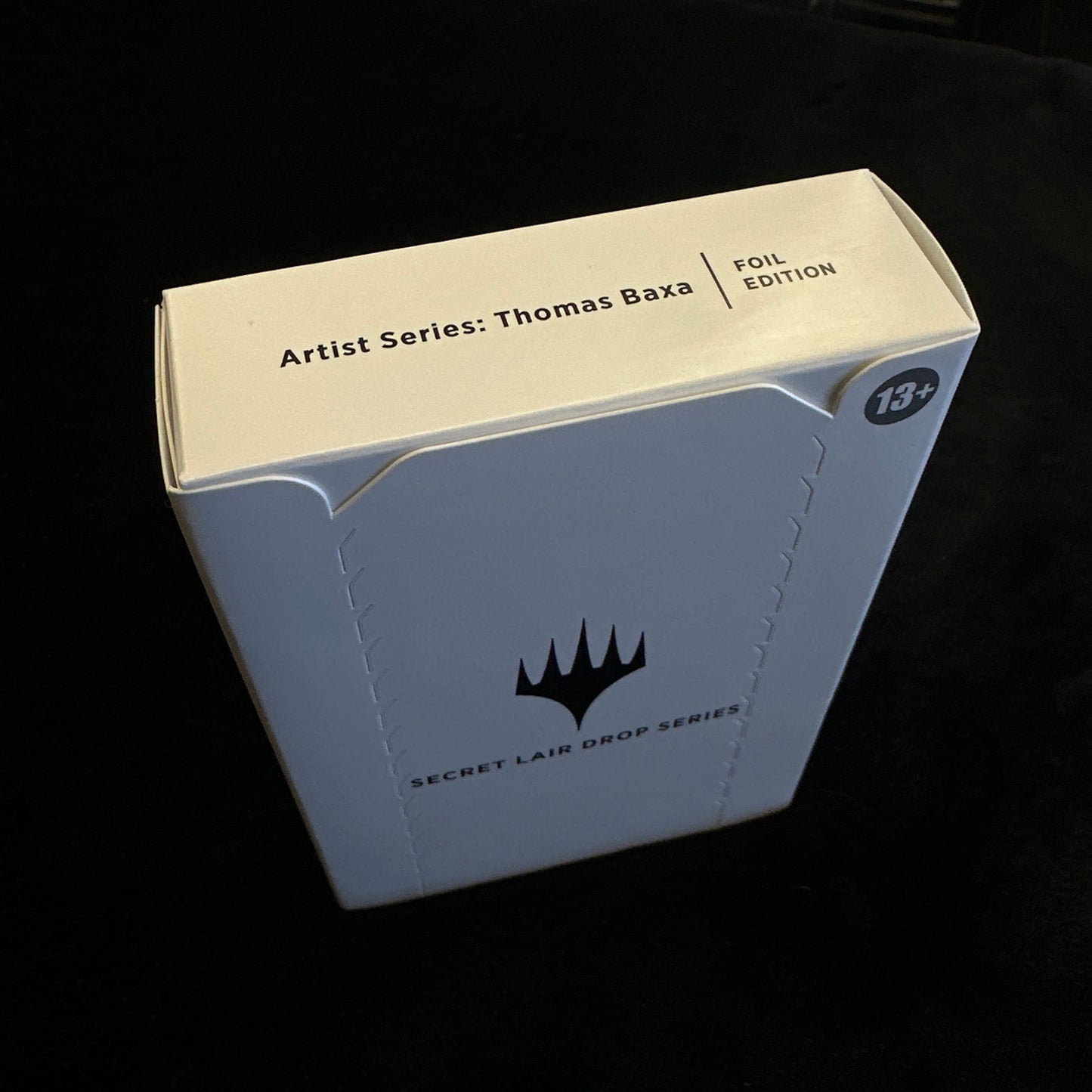 Cardboard box with MTG logo on a dark background