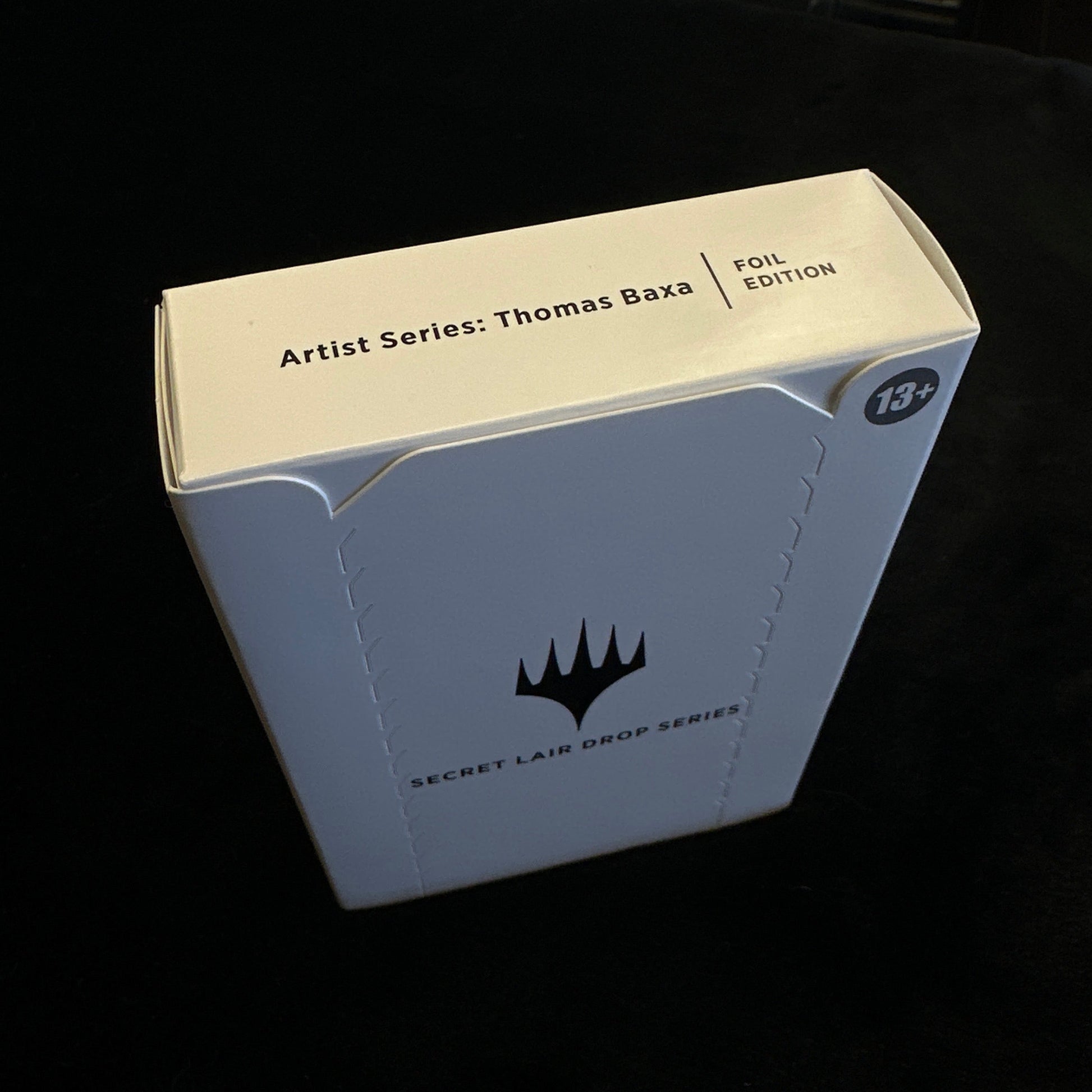 Cardboard box with MTG logo on a dark background