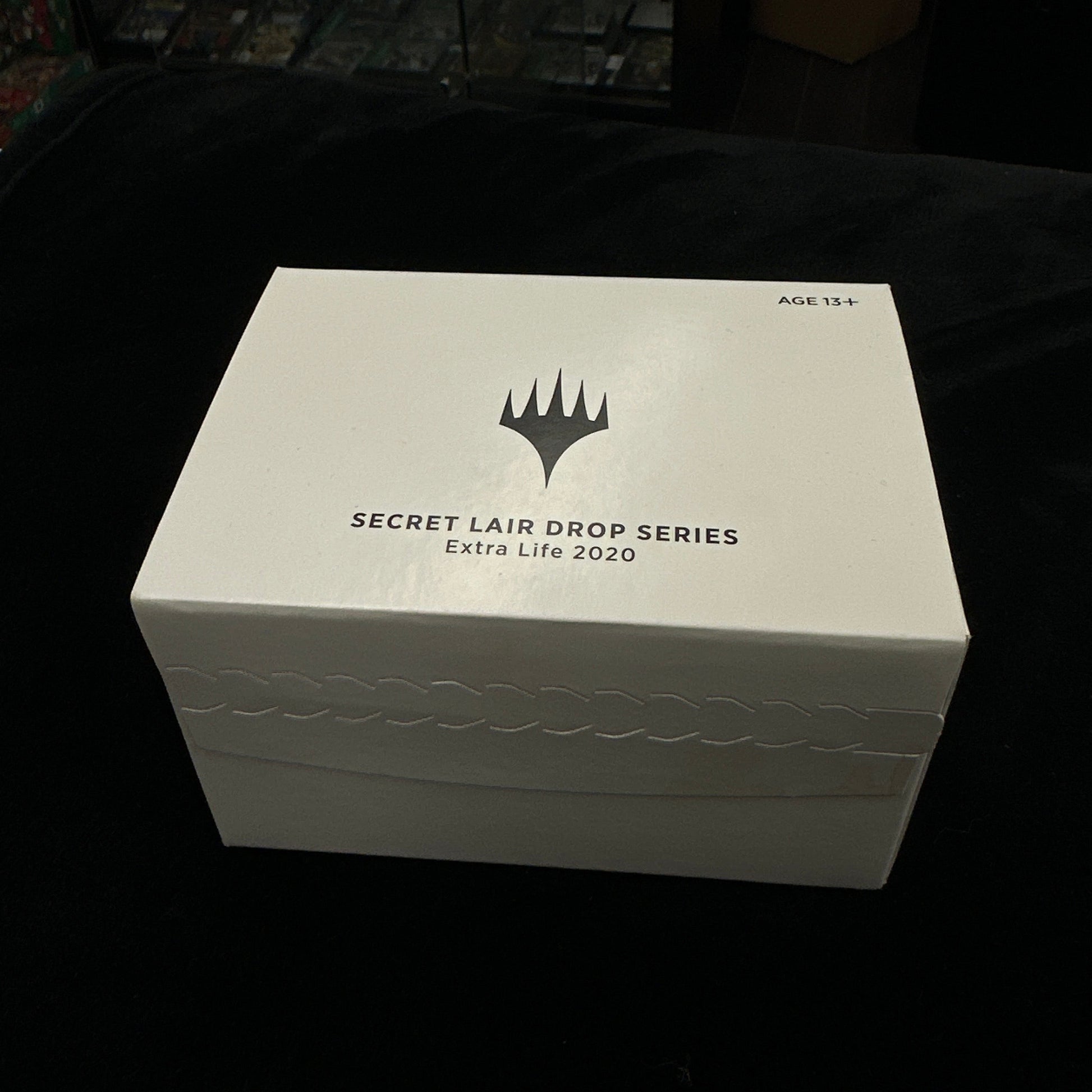 White box with a mtg logo on a dark background