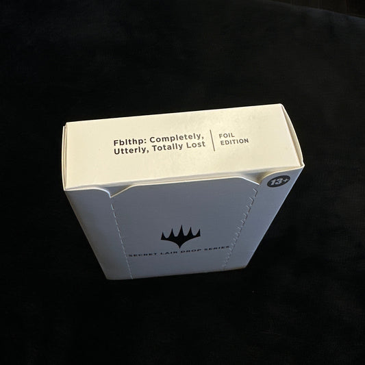 Cardboard box with text and mtg logo on a black background