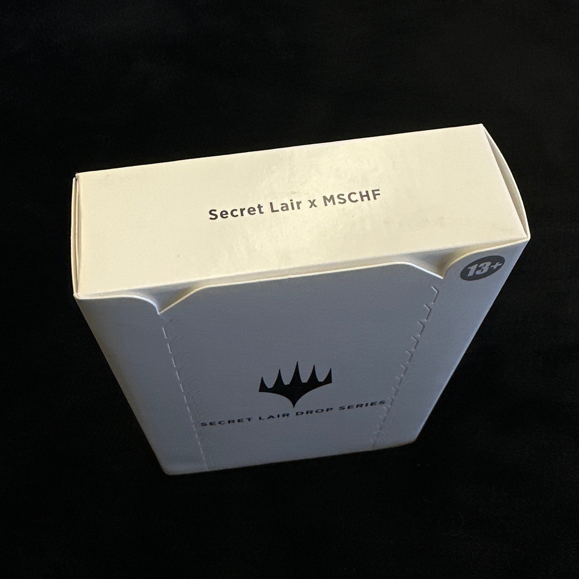 White product packaging with mtg branding on a black background