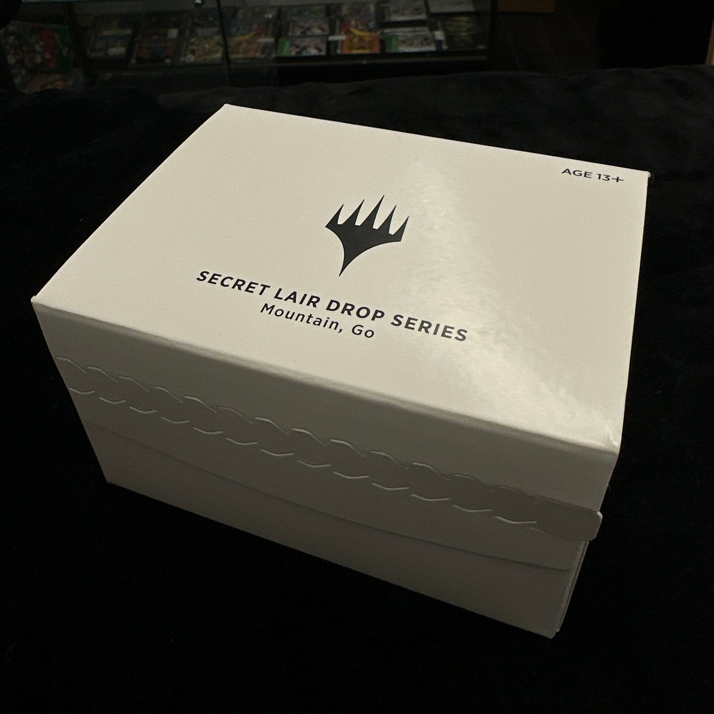 White box with mtg logo on a black background