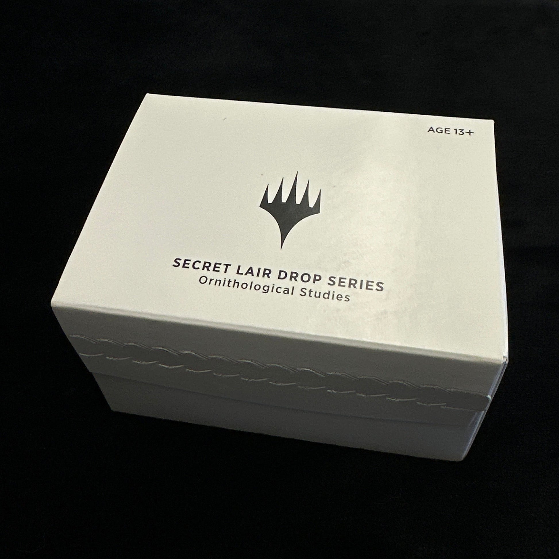 White box with text and mtg logo on a black background