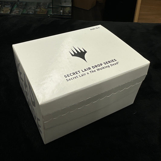White box with mtg logo on a dark background