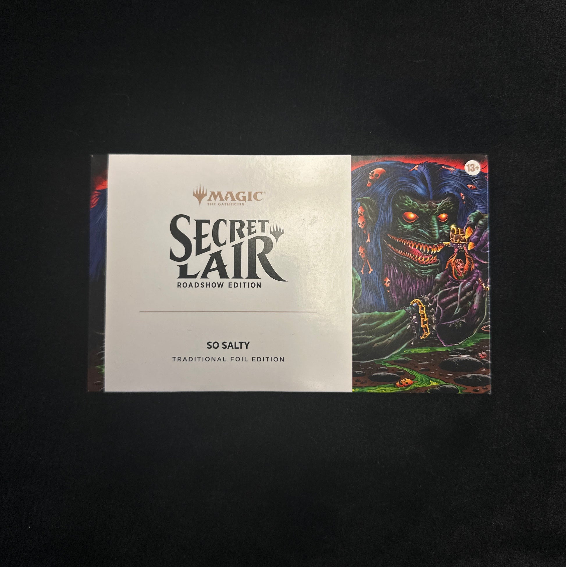 Card game box titled 'Secret Lair' with colorful artwork on a black background