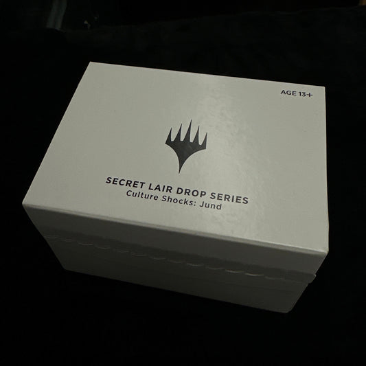 White box with mtg logo and text on a dark background