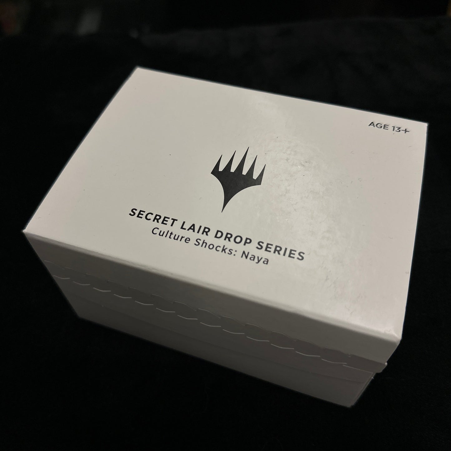 White box with black text and mtg logo on a dark background