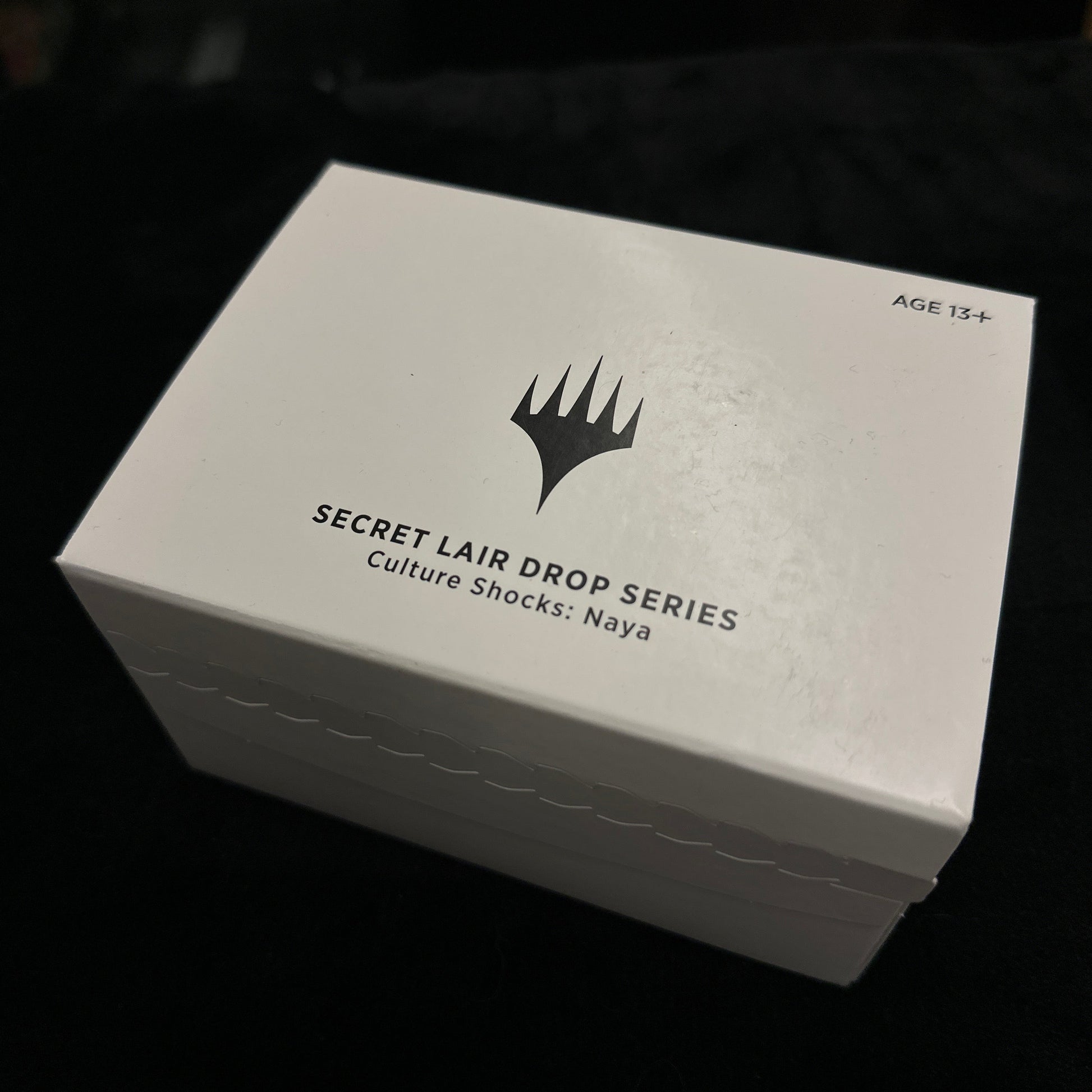 White box with black text and mtg logo on a dark background