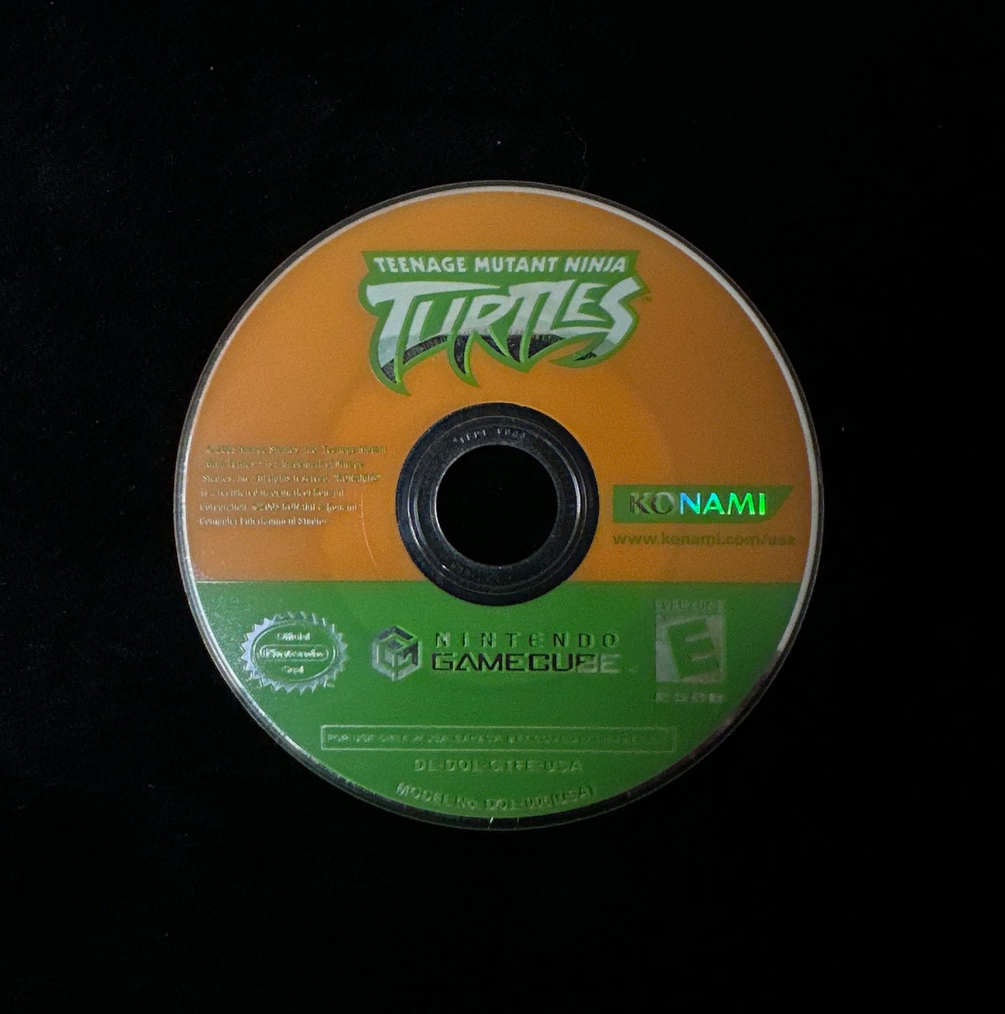 A Teenage Mutant Ninja Turtles video game disc for the Nintendo GameCube, featuring an orange and green label design, photographed on a black background.