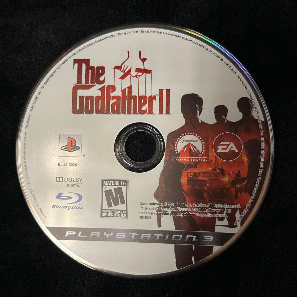A PlayStation 3 game disc for 'The Godfather II' resting on a black fabric surface.