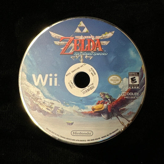 A Nintendo Wii game disc for The Legend of Zelda: Skyward resting on a black fabric surface.